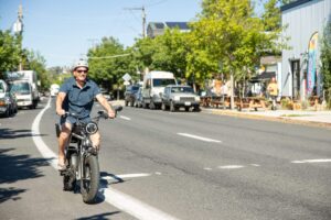 Man biking safely with helmet and glasses on the road.