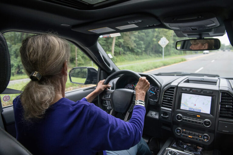 Senior woman driving on a road safely.