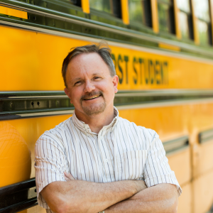 male school bus drivers in Oregon posing while leaning on the school bus
