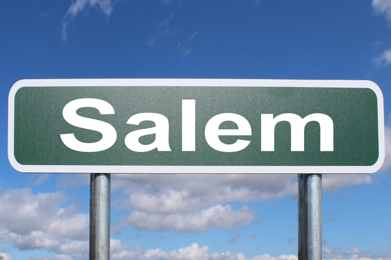 Road sign displaying the name 'Salem' against a blue sky.