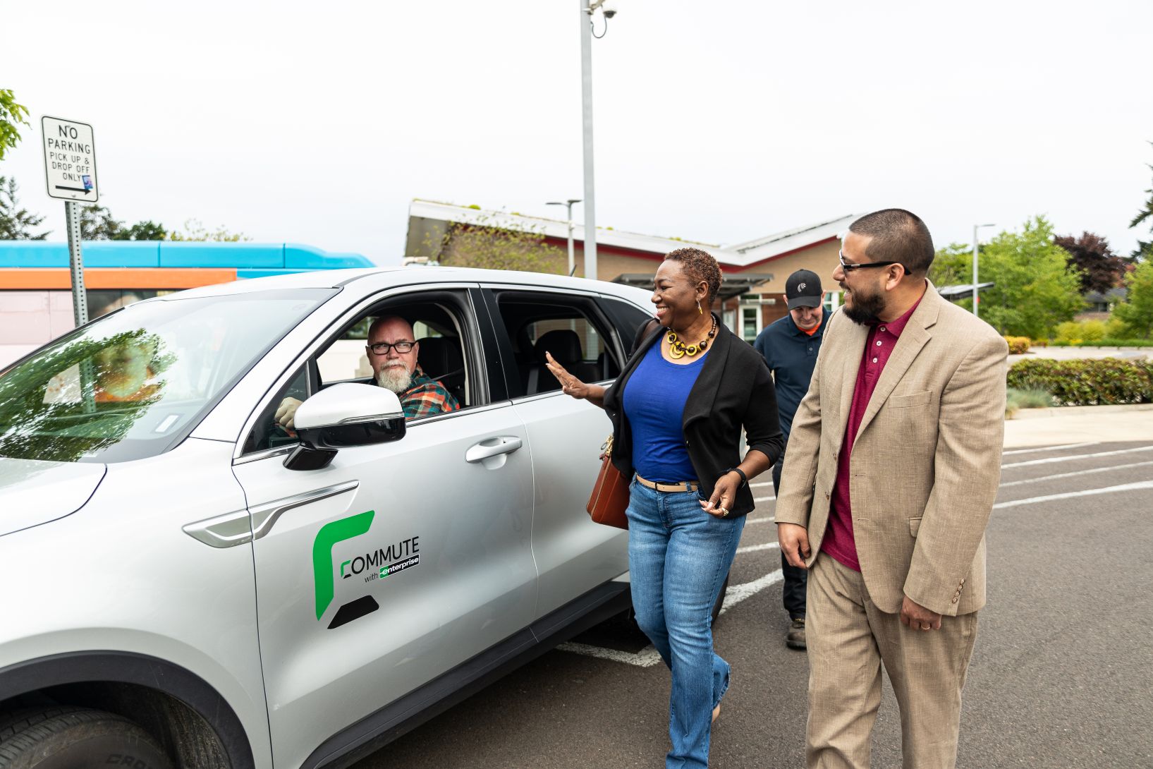 Image showing a group of people interacting with a driver in a silver car, demonstrating the power of collaboration in promoting shared transportation solutions and fostering teamwork for safer, more efficient commuting practices.
